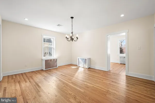 a view of empty room with wooden floor and ceiling fan