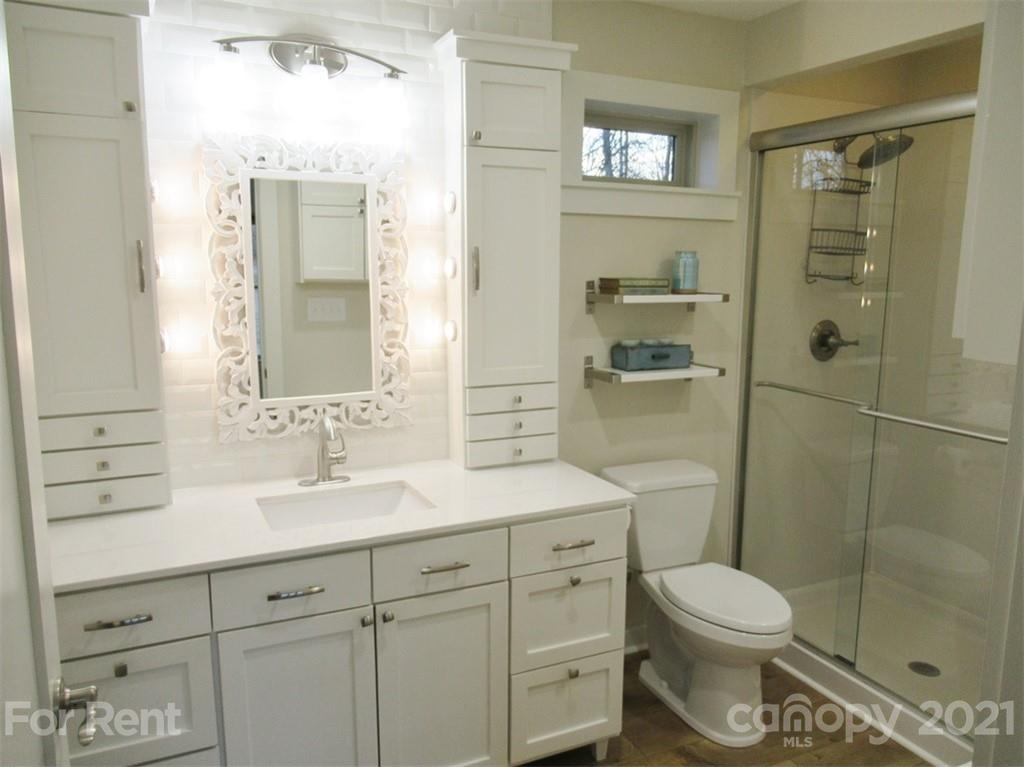 3487 Walker Road, Unit B Maiden, NC 28650 - Photo 11 of 22 a bathroom with a toilet a sink a glass door a shower a mirror and vanity