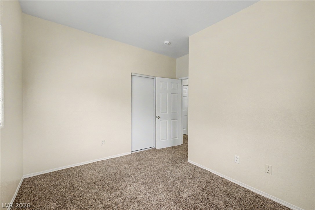 4730 East Craig Road, Unit 1091 Las Vegas, NV 89115 - Photo 21 of 23 Neutral walls and plush carpeting create a versatile, comfortable bedroom space ready for customization.