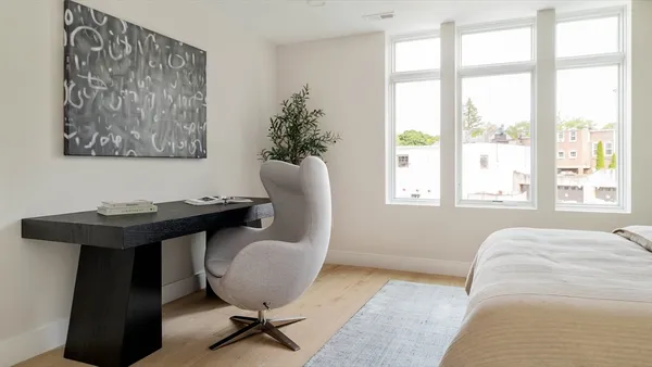 a view of a workspace with furniture and a window