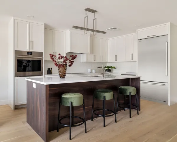 a kitchen with granite countertop a table chairs stove and cabinets
