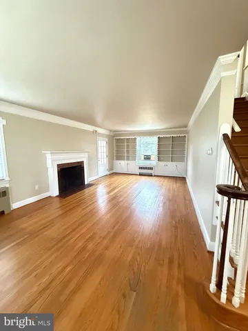 a view of empty room with wooden floor and fireplace