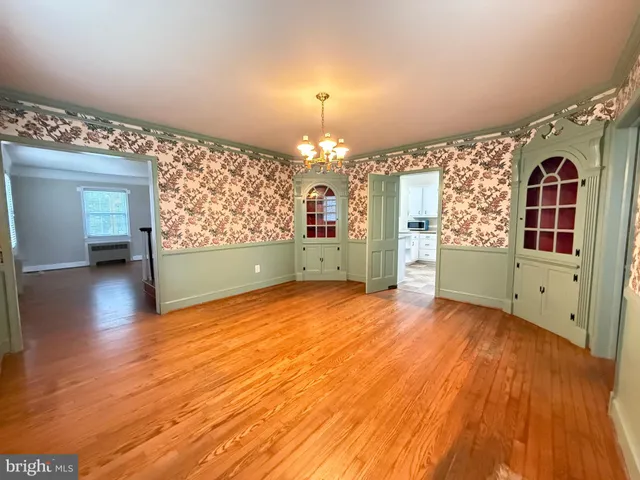 a view of a room with wooden floor staircase and a kitchen