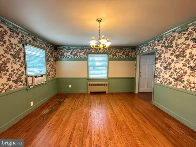 a room with window a chandelier and wooden floor