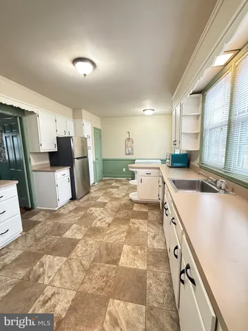 a large kitchen with a large counter top sink and stainless steel appliances