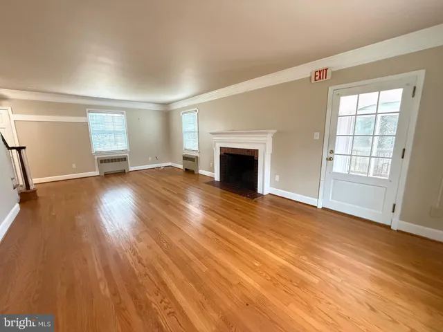 wooden floor fireplace and windows in an empty room