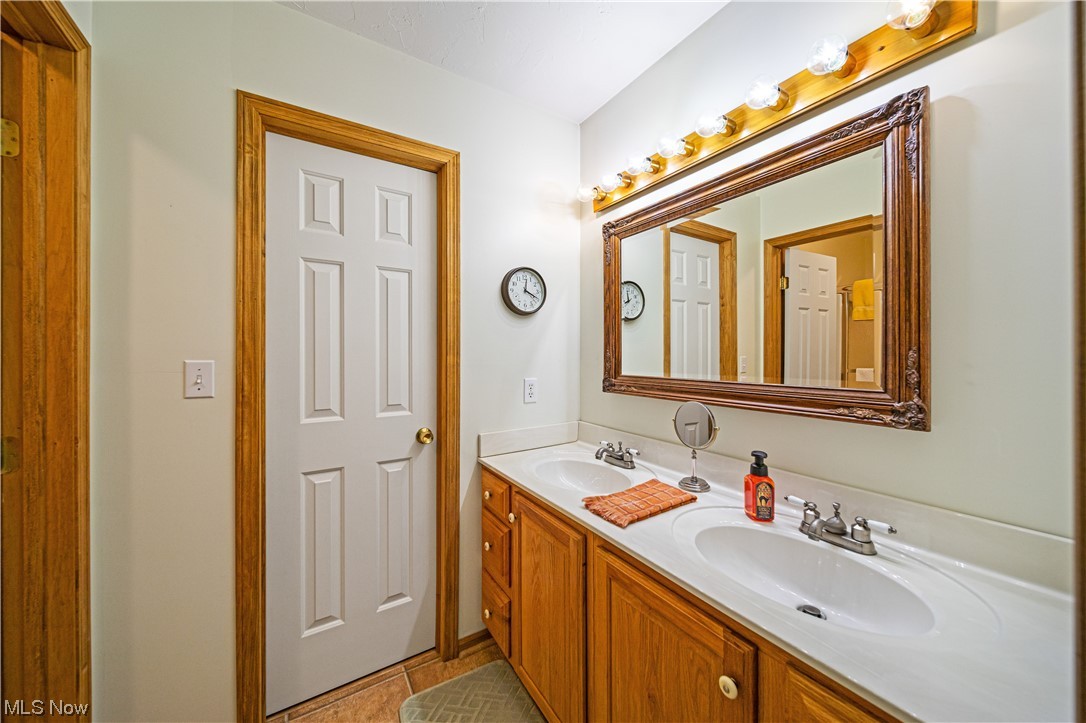 431 Ansel Road Geneva, OH 44041 - Photo 34 of 35 Bathroom featuring dual bowl vanity, mirror, and light tile floors