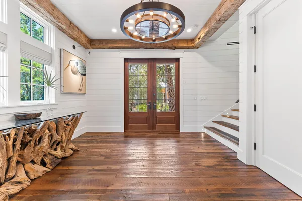 a dining room with furniture a chandelier and wooden floor