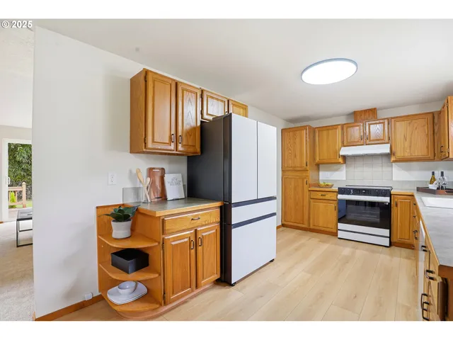 a kitchen with granite countertop a refrigerator stove and sink