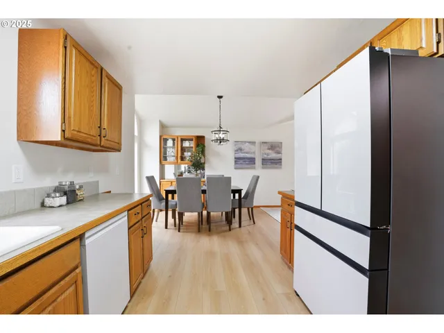 a open kitchen with stainless steel appliances granite countertop a refrigerator dining table and chairs
