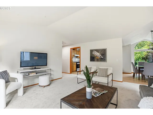 a living room with furniture a dining table and a flat screen tv