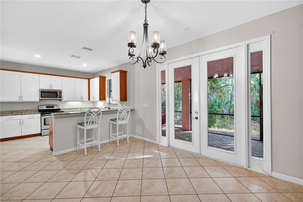 7666 Bristol Circle Naples, FL 34120 - Photo 3 of 20 a open kitchen with stainless steel appliances granite countertop a refrigerator and a stove top oven