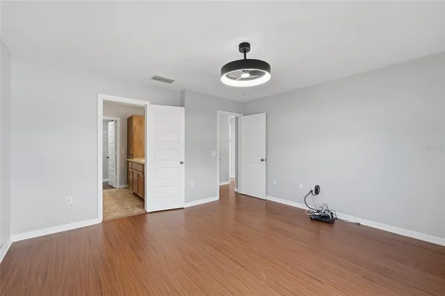 a view of a room with wooden floor and fan