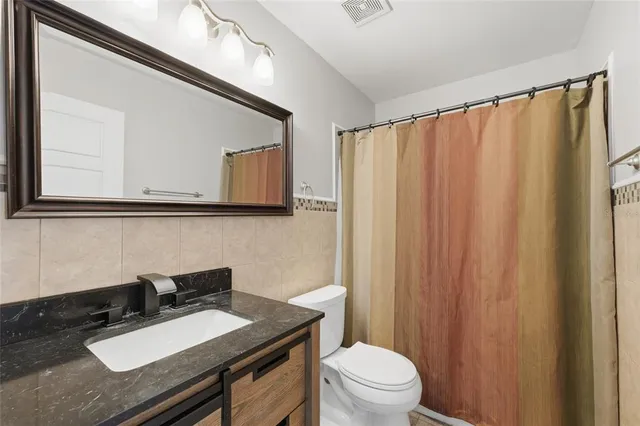 a bathroom with a sink a toilet and mirror