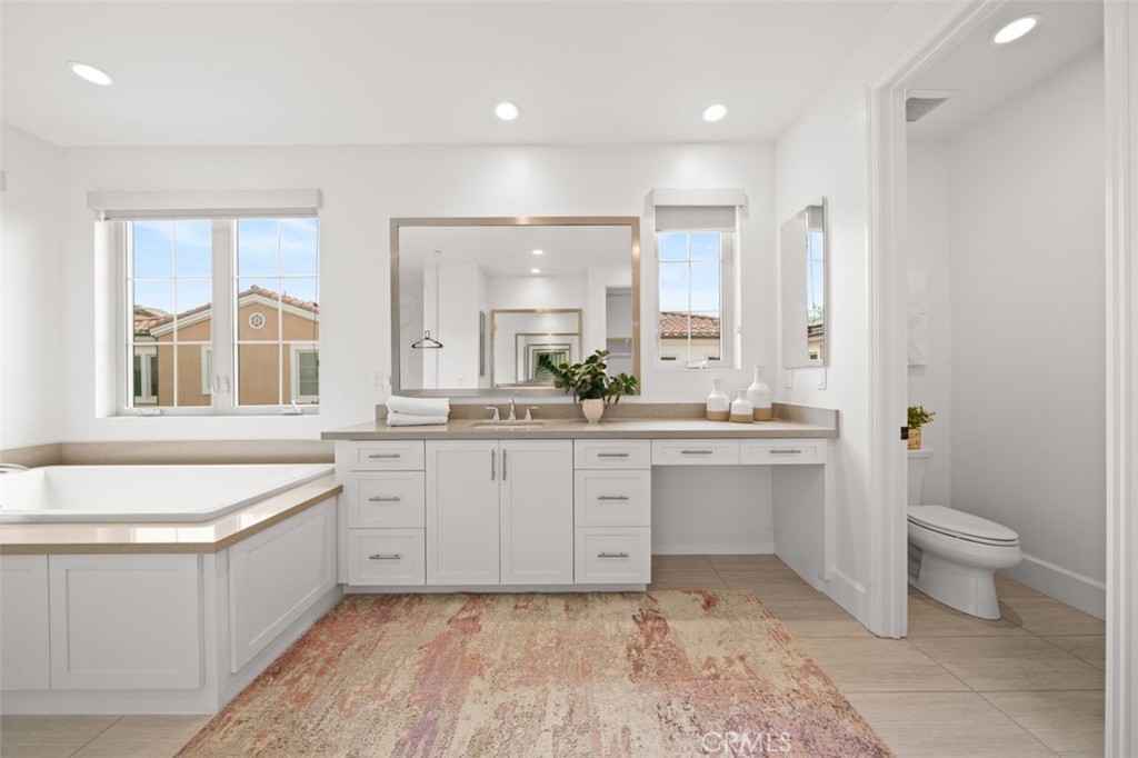 90 Rockinghorse Irvine, CA 92602 - Photo 17 of 30 a large bathroom with a double vanity sink a large mirror and a bathtub