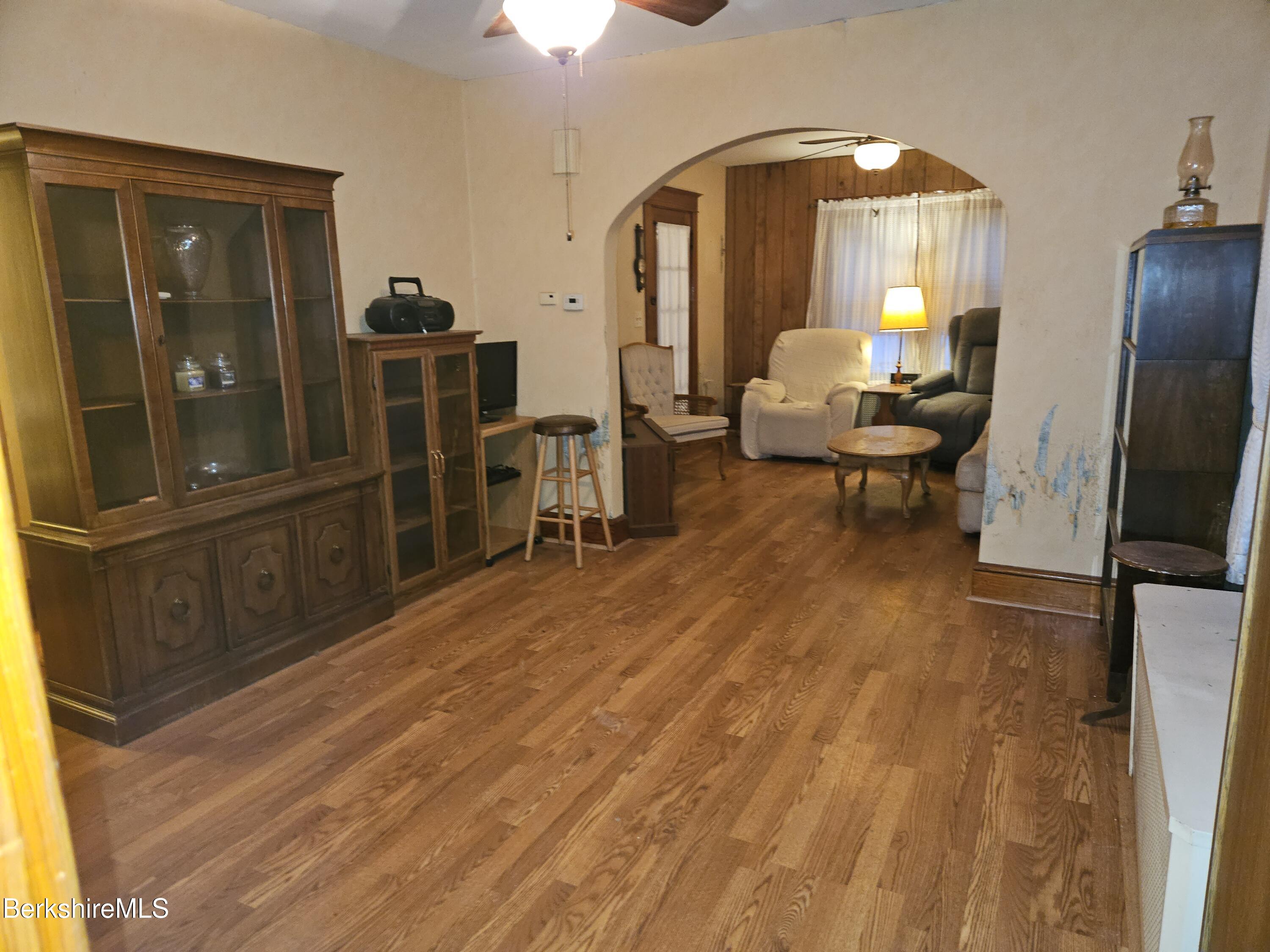 269 2nd Street Pittsfield, MA 01201 - Photo 9 of 39 a living room with furniture a large mirror and a dining table with wooden floor