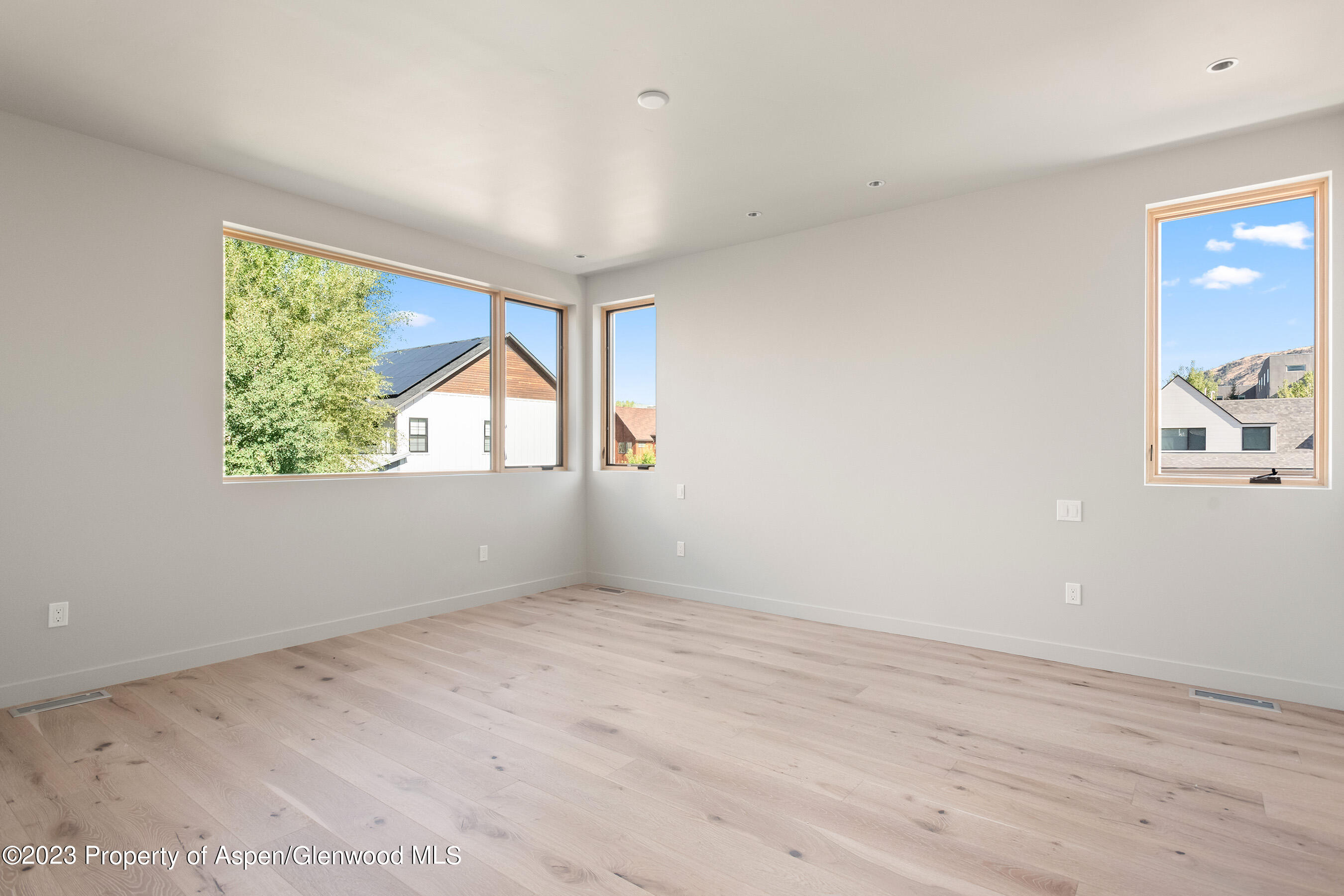 128 Valley Court Basalt, CO 81621 - Photo 8 of 12 an empty room with wooden floor and windows