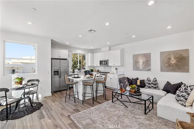 a living room with lots of furniture and a dining table with kitchen view