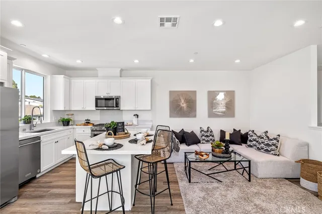 a kitchen with stainless steel appliances kitchen island granite countertop a sink and chairs
