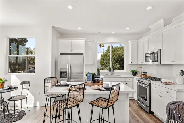 a kitchen with a table chairs refrigerator and cabinets
