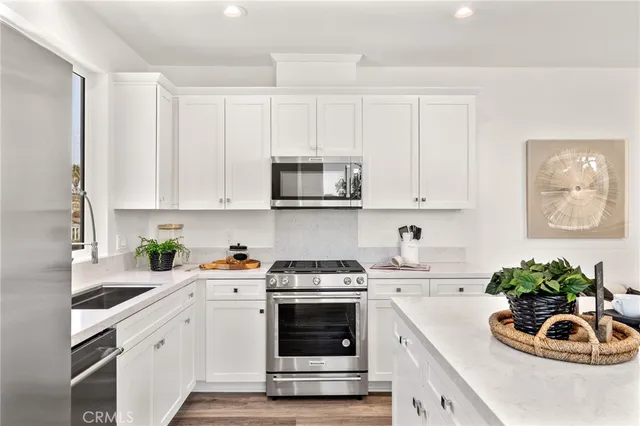 a kitchen with white cabinets and white appliances