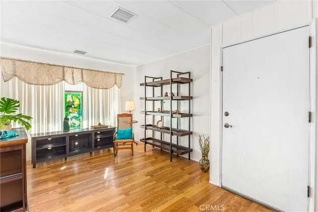 a living room with furniture floor to ceiling window and wooden floor