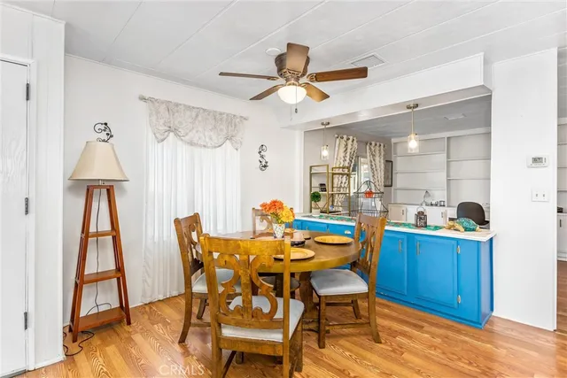 a dining room with furniture and a chandelier fan