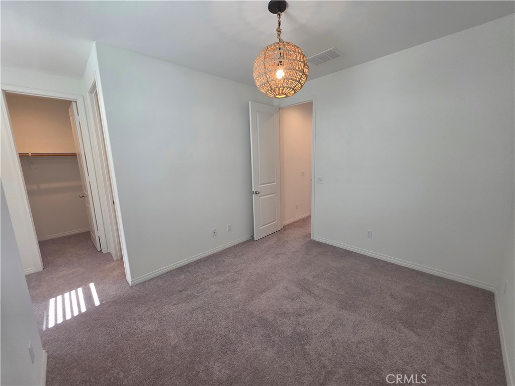 120 Rondo Irvine, CA 92618 - Photo 13 of 23 an empty room with a chandelier fan and wooden floor