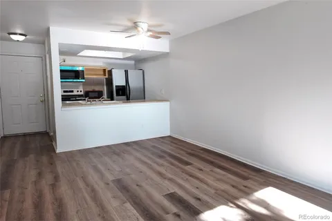 a view of a room with wooden floor and a ceiling fan