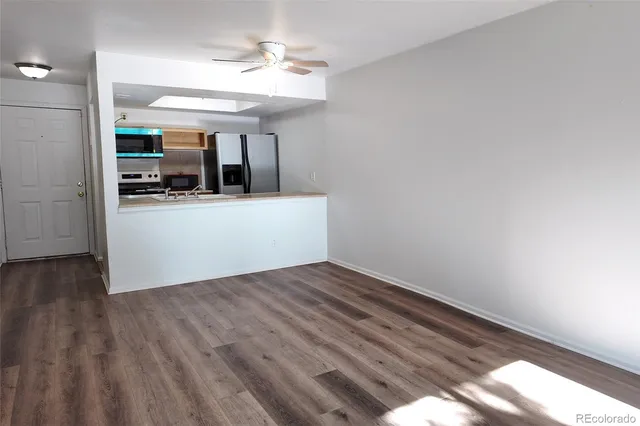 a view of a room with wooden floor and a ceiling fan
