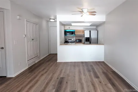 a view of a kitchen with wooden floor and a ceiling fan