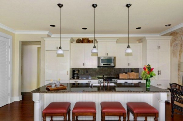 2373 Ho'ohu Road, Unit E111 Koloa, HI 96756 - Photo 3 of 16 a kitchen with granite countertop a table chairs stove and cabinets