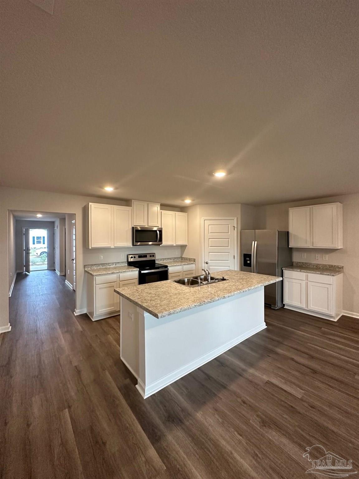 4378 Redbay Court Pace, FL 32571 - Photo 12 of 30 a kitchen with stainless steel appliances a stove top oven a sink dishwasher and a refrigerator with wooden floor
