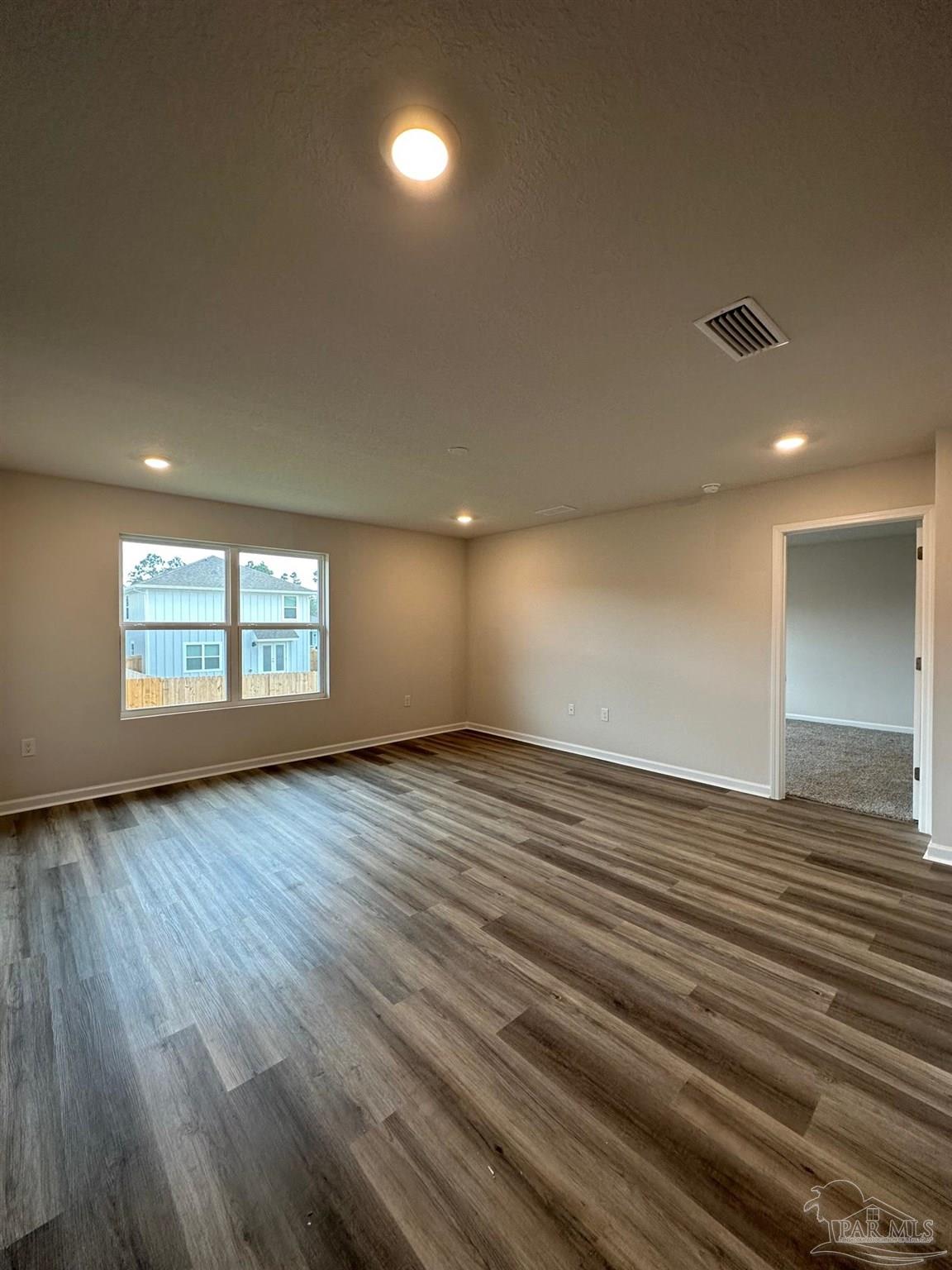 4378 Redbay Court Pace, FL 32571 - Photo 15 of 30 an empty room with wooden floor and windows