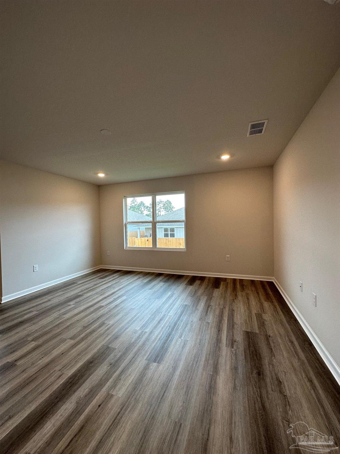 4378 Redbay Court Pace, FL 32571 - Photo 16 of 30 an empty room with wooden floor and windows