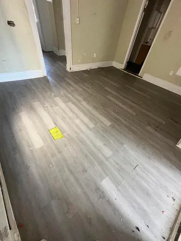 a view of a hallway with wooden floor and closet