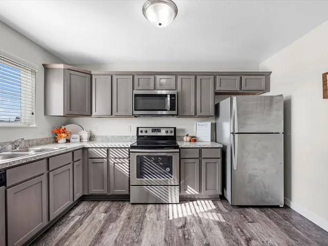 a kitchen with a sink a microwave a refrigerator and cabinets