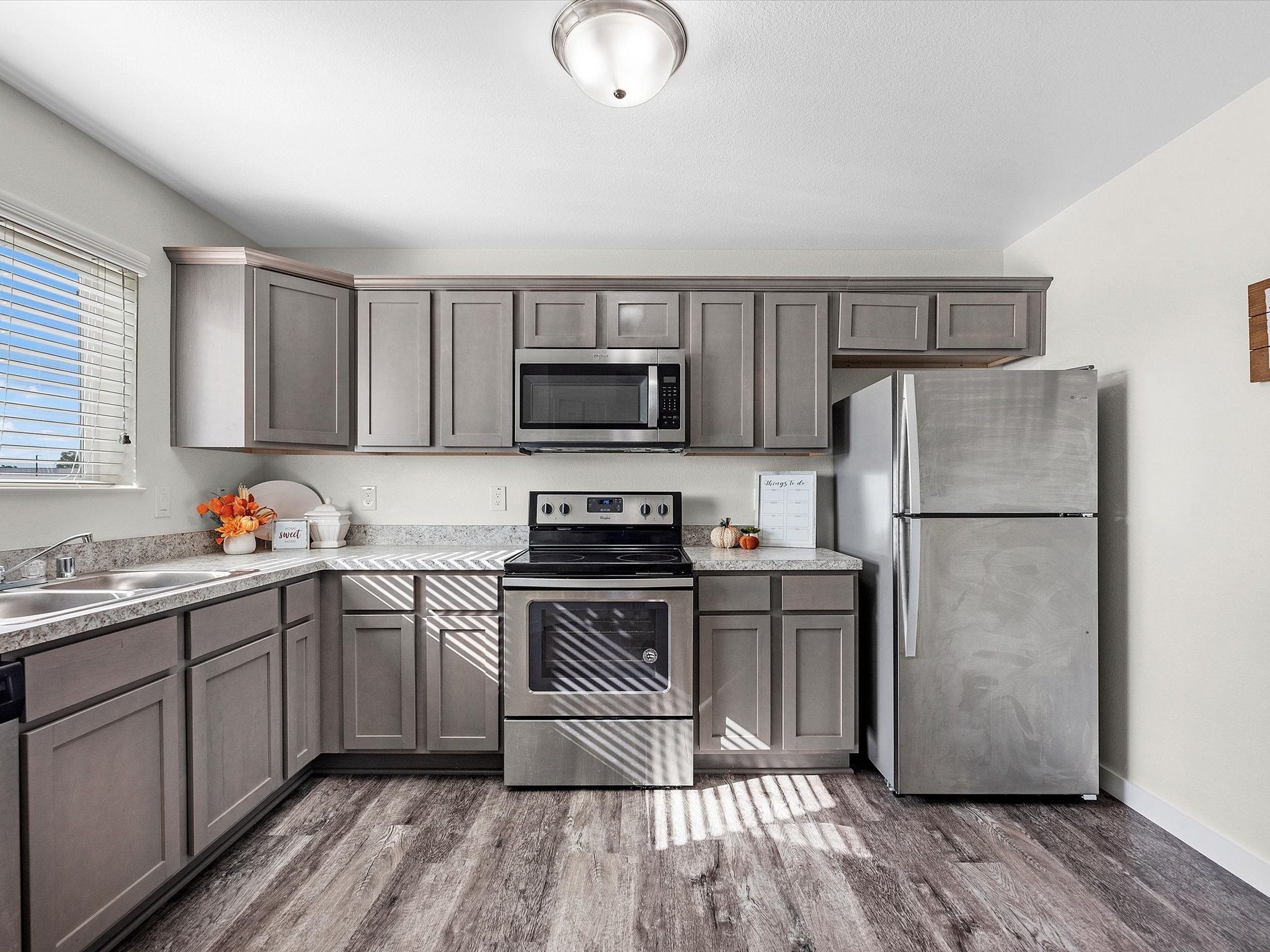 12603 Telge Road, Unit 13E Cypress, TX 77429 - Photo 2 of 32 a kitchen with a sink a microwave a refrigerator and cabinets