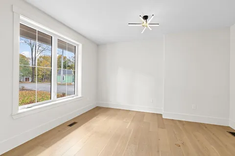 an empty room with a window and a ceiling fan