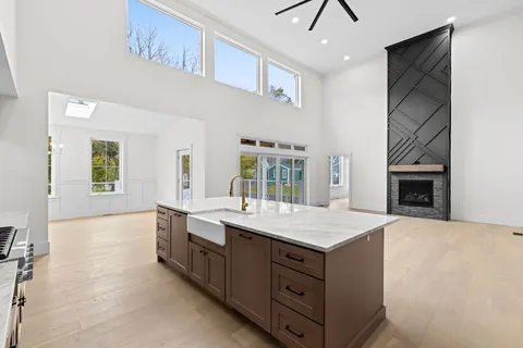 a spacious bathroom with a granite countertop sink a toilet a mirror and shower