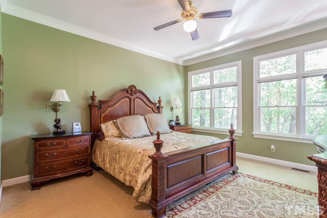 10001 Goodview Court Raleigh, NC 27613 - Photo 2 of 25 Large master bedroom with high ceiling, huge windows, door leading to the deck, and wood-burning fireplace