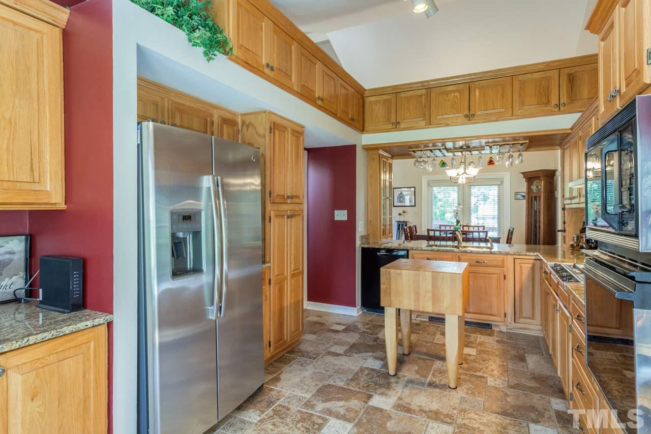 10001 Goodview Court Raleigh, NC 27613 - Photo 6 of 25 Spacious updated kitchen with granite, tile backsplash, and tile flooring. Beautiful overhead cabinetry with plenty of additional storage.