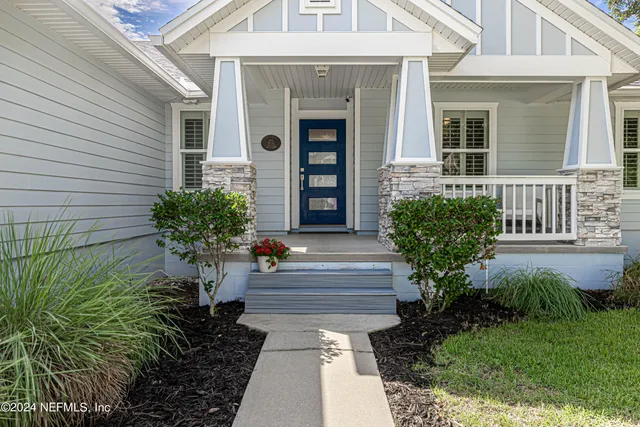 a front view of a house with potted plants