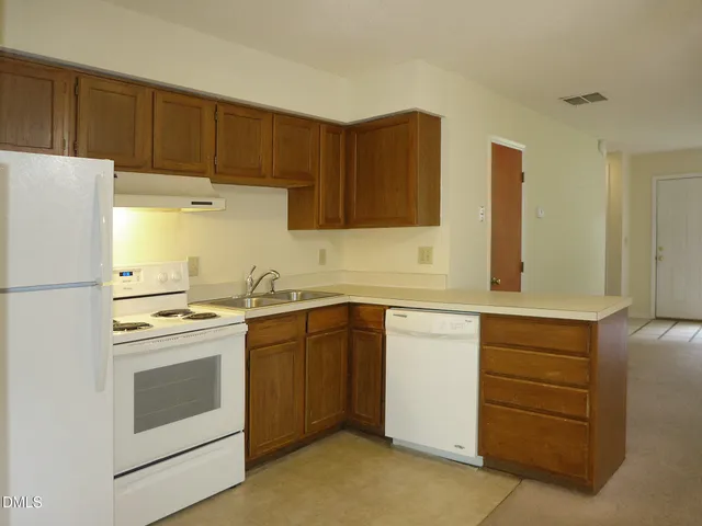 a kitchen with a stove white cabinets and white appliances