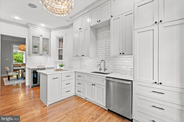 a kitchen with stainless steel appliances white cabinets and wooden floors
