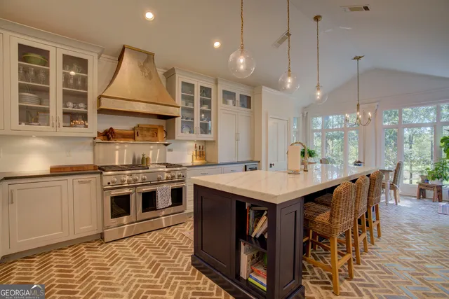 a spacious bedroom with a bed a chandelier and a fireplace