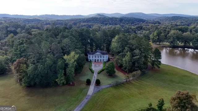 an aerial view of a house with garden space and a lake view