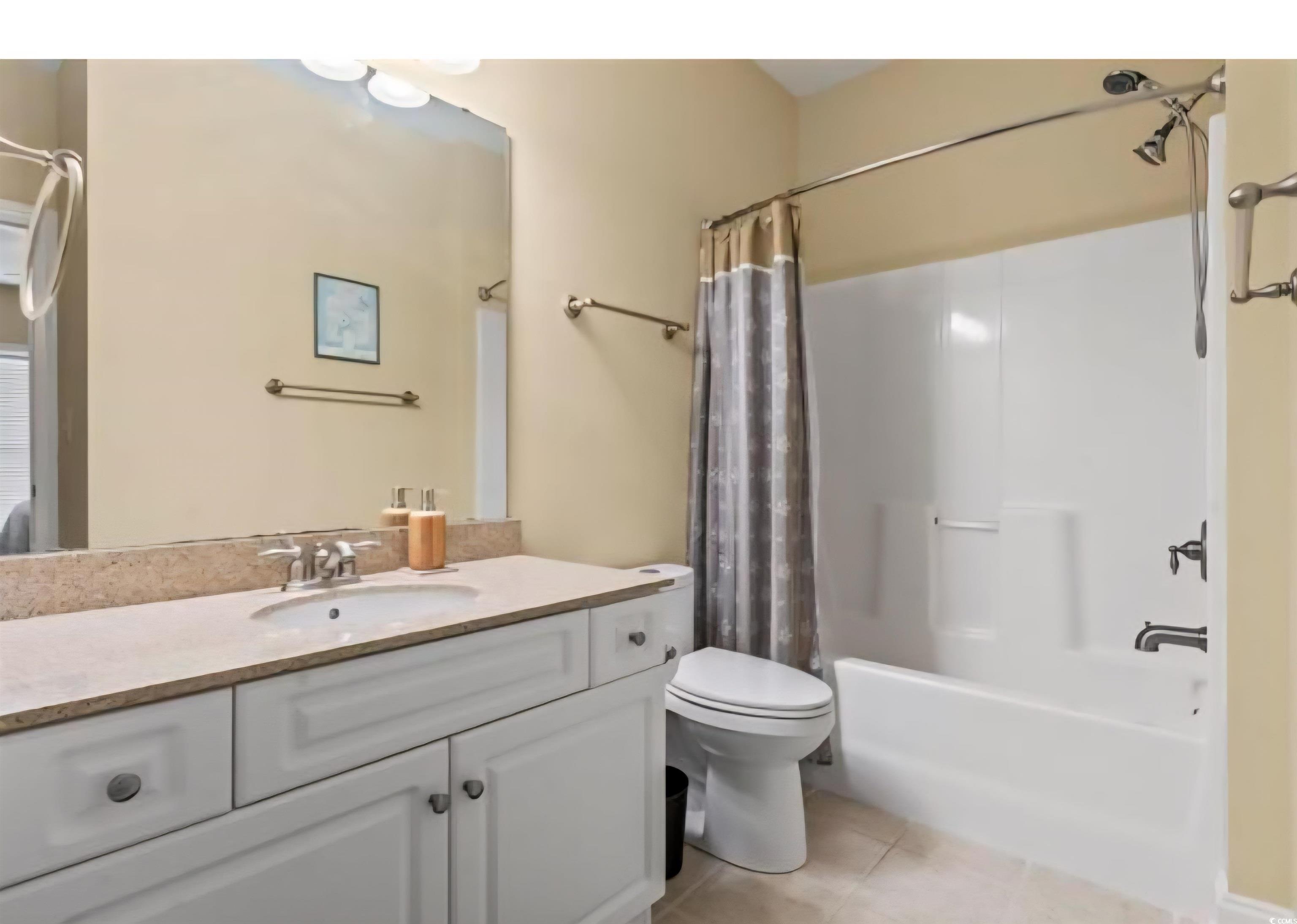 1009 World Tour Boulevard Myrtle Beach, SC 29579 - Photo 15 of 36 Full bath featuring shower / tub combo with curtain, vanity, and light tile patterned floors