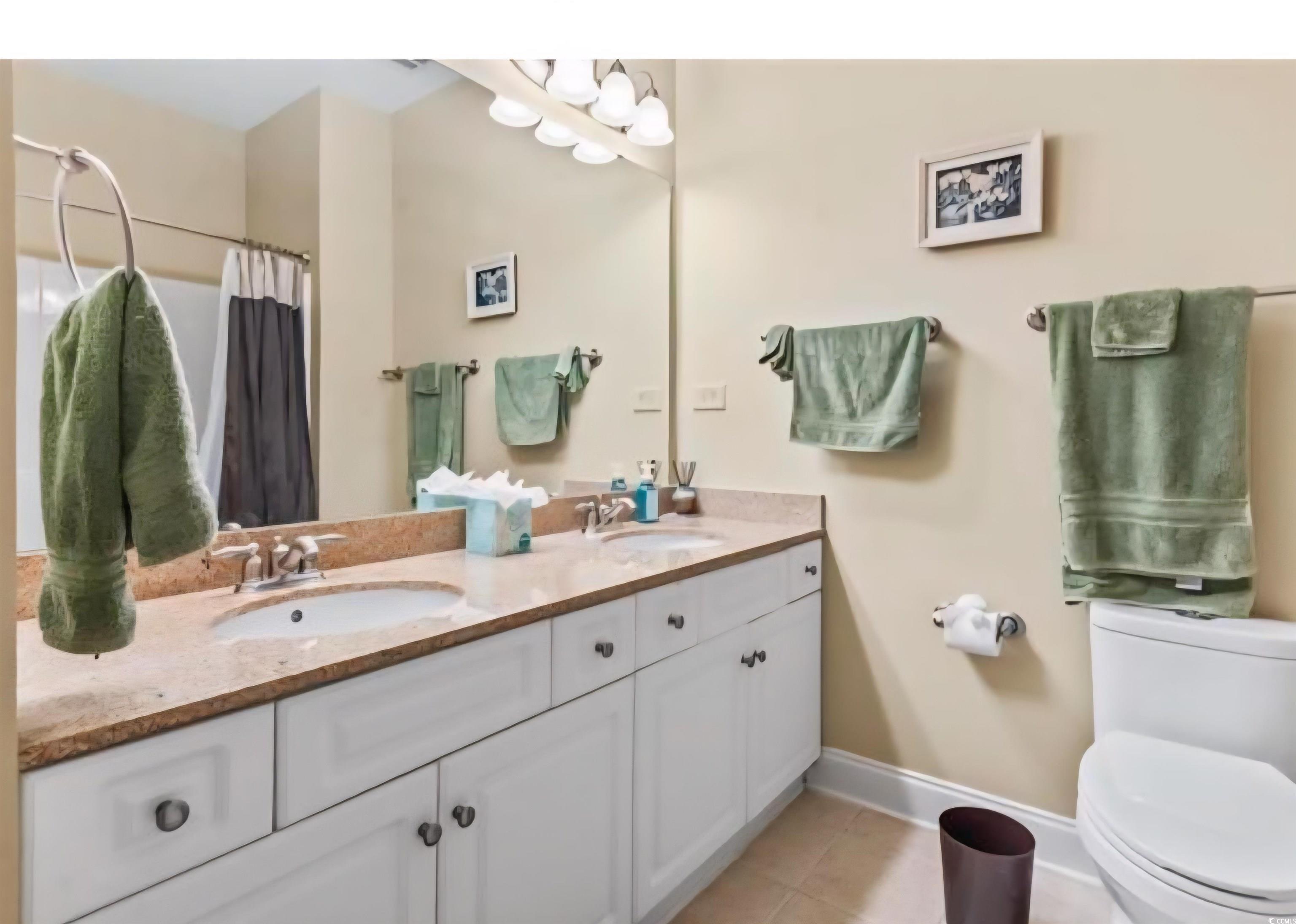 1009 World Tour Boulevard Myrtle Beach, SC 29579 - Photo 16 of 36 Full bath with double vanity, light tile patterned floors, and a shower with curtain