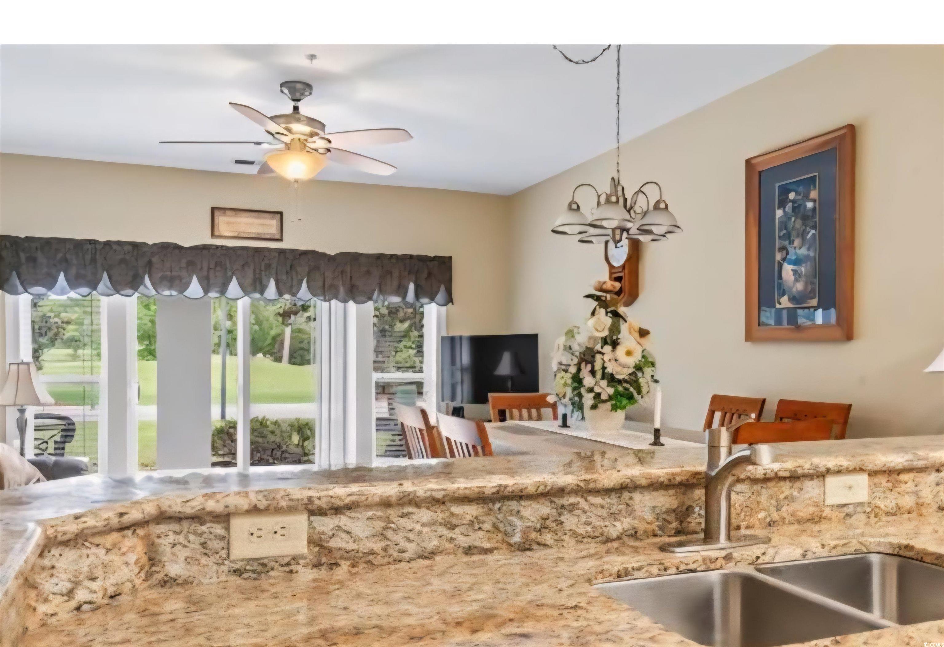1009 World Tour Boulevard Myrtle Beach, SC 29579 - Photo 36 of 36 Kitchen with ceiling fan, light stone countertops, decorative light fixtures, a chandelier, and open floor plan